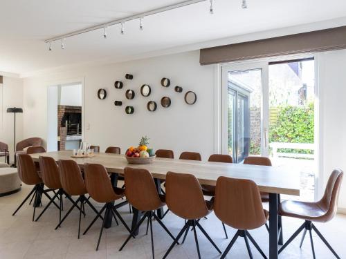 a dining room with a large wooden table and chairs at Heated Pool & Beach Access in Koksijde