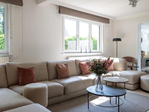 a living room with a couch and a table at Heated Pool & Beach Access in Koksijde