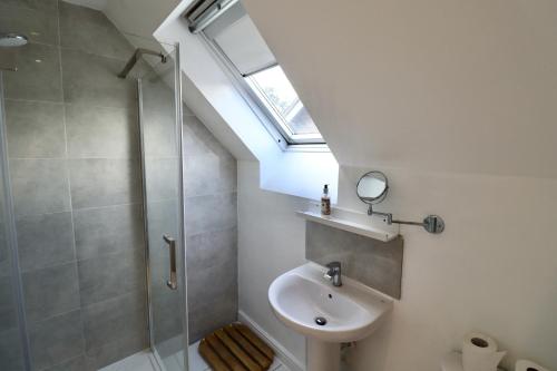 a bathroom with a sink and a shower with a skylight at Spacious 4-Bed Home in Bracknell in Bracknell