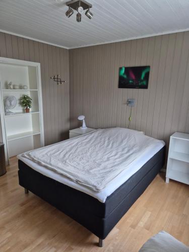 a bedroom with a bed and a tv on the wall at Hybelleilighet - Privat - no parking in Tromsø
