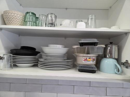a kitchen shelf with plates and cups and dishes at Casa da Praceta in Torres Vedras