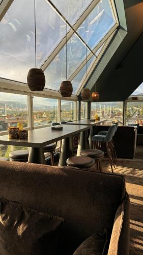 un restaurante con mesa, sillas y una gran ventana en Aksjemøllen - by Classic Norway Hotels, en Lillehammer