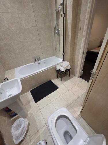 a bathroom with a tub and a toilet and a sink at The White Hart Hull in Hull