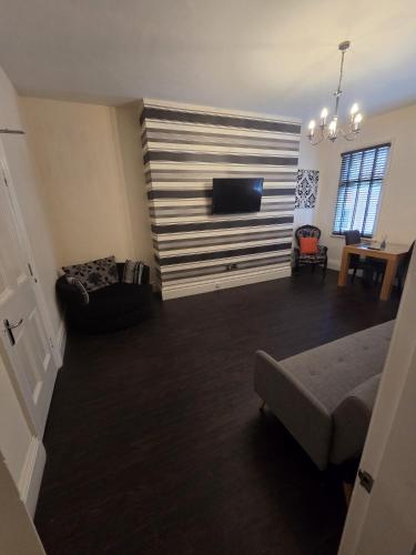 a living room with a couch and a flat screen tv at The White Hart Hull in Hull