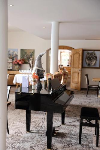 a black piano sitting in a living room at Hotel Waldhaus am See in St. Moritz