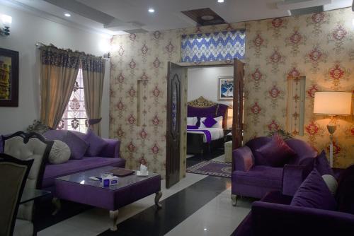 a living room with purple couches and a bedroom at Premier Inn Grand Gulberg Lahore in Lahore