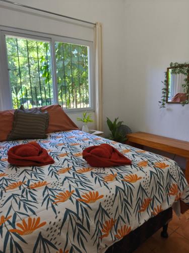 a bed with red pillows on it in a bedroom at Melany's House's in Ajaxá