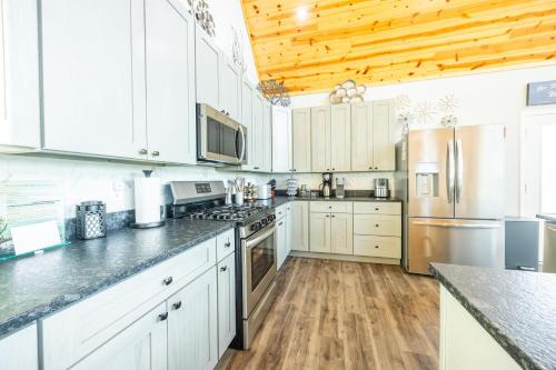a kitchen with white cabinets and stainless steel appliances at Black Diamond By Masontyler in Davis