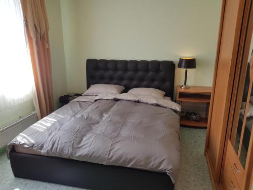 una camera da letto con un letto grande con testiera nera di 2-room apartment in the house with the SEPARATE ENTRANCE & FREE parking a Riga