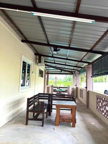 a patio with benches and tables in a building at Teratak EppyHoney'S in Kota Tinggi