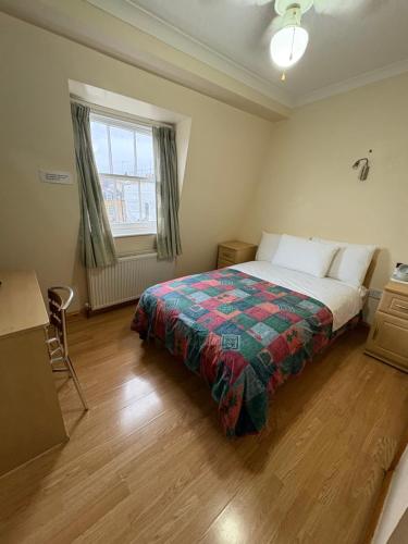 a bedroom with a bed and a window at Carlton Hotel annexe in London
