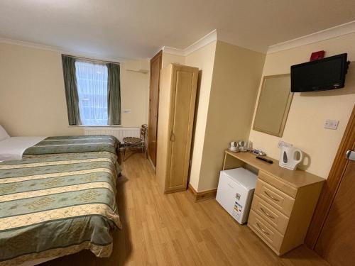 Una cama o camas en una habitación de Carlton Hotel annexe