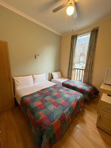 a hotel room with two beds and a window at Carlton Hotel annexe in London