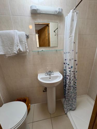 a bathroom with a sink and a toilet and a mirror at Carlton Hotel annexe in London