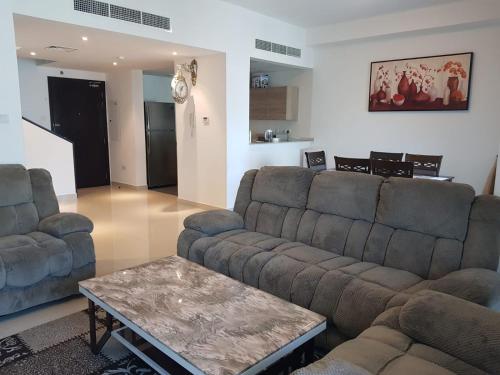 a living room with two couches and a coffee table at Nasmah Star in Juffair