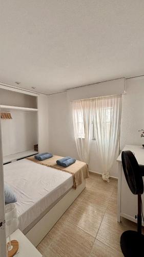 a bedroom with a large bed and a window at BeachFront Apartment in Gandia in Puerto de Gandía