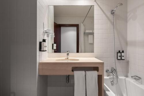a bathroom with a sink and a mirror and a tub at Crisol Tres Pastorinhos in Fátima