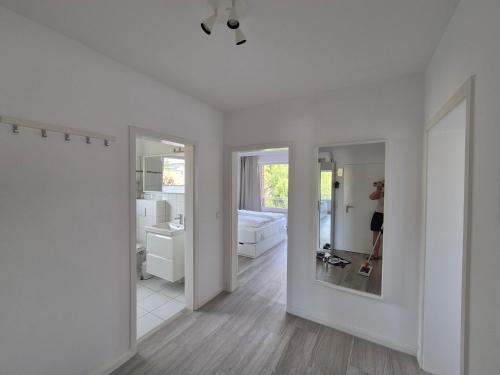 a woman taking a picture of a bathroom with a mirror at FeWo Machedanz strandnah Timmendorf Strand in Timmendorfer Strand