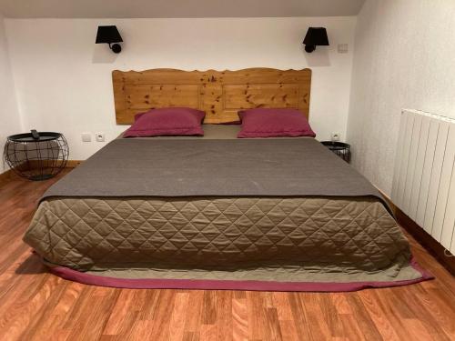 a large bed in a bedroom with a wooden floor at Chalet Duplex 4P pour 8 pers, Rénové, Piscine, 300m des Pistes, Terrasse, Parking - FR-1-504-433 in Superdevoluy