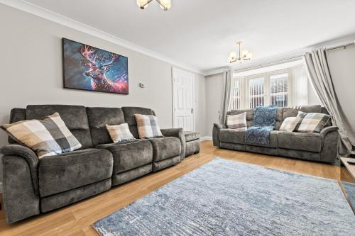 a living room with a couch and a table at Polmont Haven: Spacious 4- Bedroom Retreat in Polmont