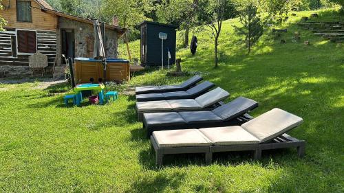 a row of chaise lounges sitting in the grass at Casa Radu - Zece Hotare in Zece Hotare