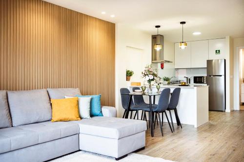 a living room and kitchen with a couch and a table at Hidden Corner by Sabugo House in Ponta do Sol