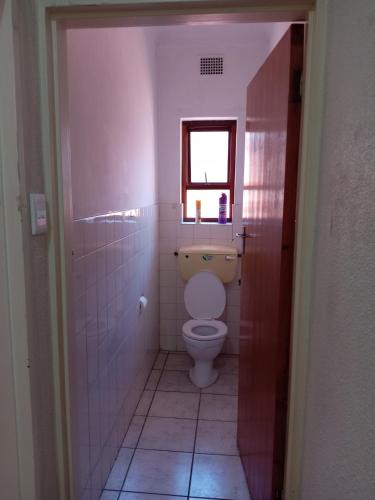 a small bathroom with a toilet and a window at Beyond Expectation in Avondale