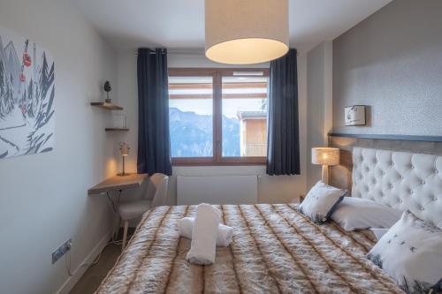 a bedroom with a large bed and a window at Alpe d'Huez Houses - Chez Robin - Fermes de l'Alpe - Flambant neuf et magnifique 4 chambres Plein SUD in L'Alpe-d'Huez