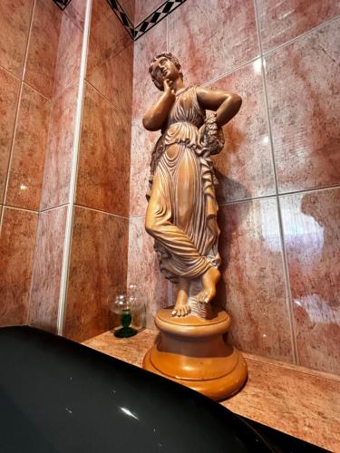 a statue of a woman sitting on a table at La Petite Source in Dabo
