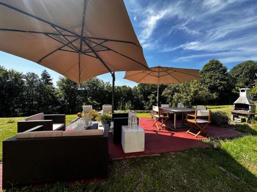a patio with a table and chairs and an umbrella at La Petite Source in Dabo