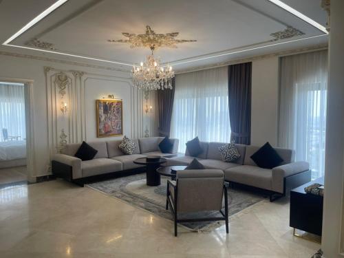 a large living room with couches and a chandelier at World Heart Residences in Baghdad