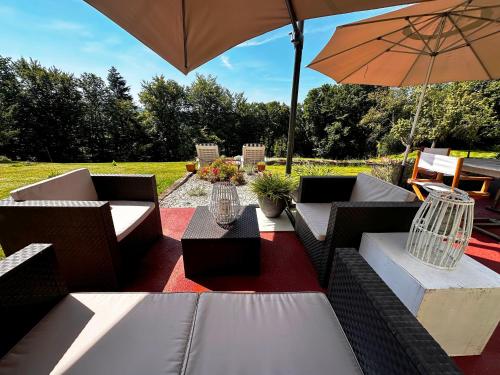 an outdoor patio with couches and an umbrella at La Petite Source in Dabo