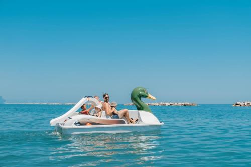 a group of people on a dolphin boat in the water at Natural Village Resort in Porto Potenza Picena