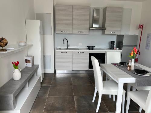 a kitchen with white cabinets and a table and chairs at Como Urban Loft - Parcheggio privato in Como