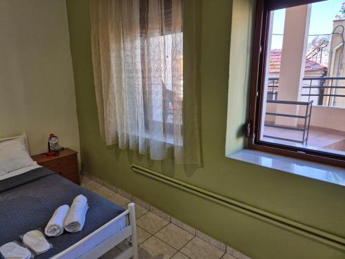 a bedroom with a bed and a window with white shoes at Old Town Apartment in Kavala