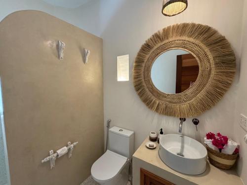 a bathroom with a sink and a mirror and a toilet at Casa Binti Ghepard Towers in Watamu