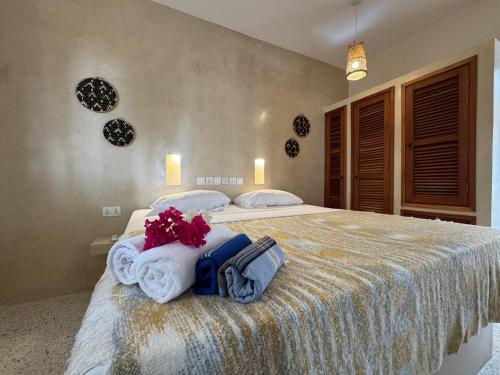 a bedroom with a large bed with flowers on it at Casa Binti Ghepard Towers in Watamu