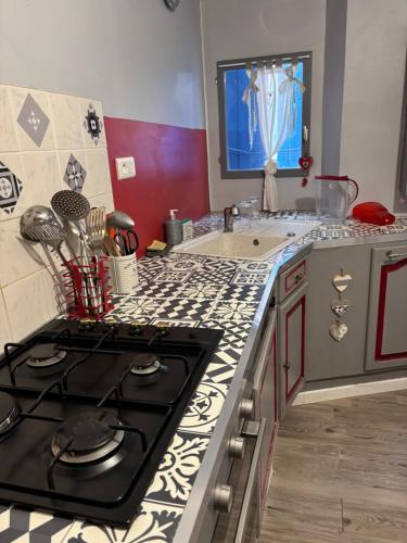 une cuisine avec une cuisinière et un plan de travail dans l'établissement maison Odjas, à Saint-Laurent-de-la-Cabrerisse