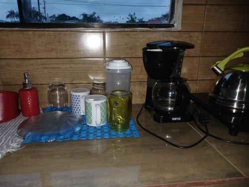 a counter with coffee cups and a coffee maker at La casita de Miguel in Villarrica