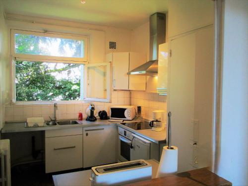 une petite cuisine avec un évier et une fenêtre dans l'établissement LIMoGES mairie, appart , parkingS ,, à Limoges