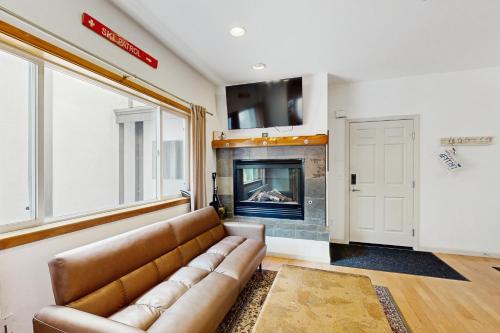 a living room with a couch and a fireplace at Olympic Pines Lodge in Olympic Valley