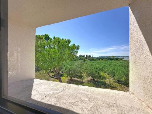 a window in a building with a view of a tree at les gites de la Fée in Cavaillon
