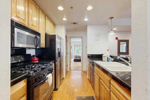 a kitchen with wooden cabinets and a stove top oven at Olympic Pines Lodge in Olympic Valley