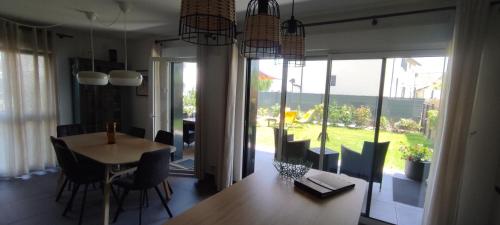 a dining room with a table and chairs and a large window at L'Escale du Léman in Publier