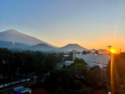 a sunrise over a city with mountains in the background at Tai Africa Guest Rooms in Arusha