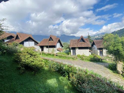 a group of houses with roofs on a field at Sapa Heaven - Sapa Jade Hill in Sa Pa