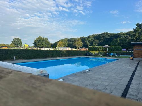 a swimming pool with blue water in a yard at Figaro - Gasselte, Drenthe, 4 persoons, airco in Gasselte