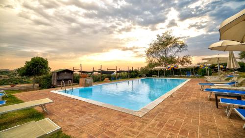 a large swimming pool with blue lounge chairs around it at Tenuta dell'Argento Pool&Relax by Rentbeat in Civitavecchia