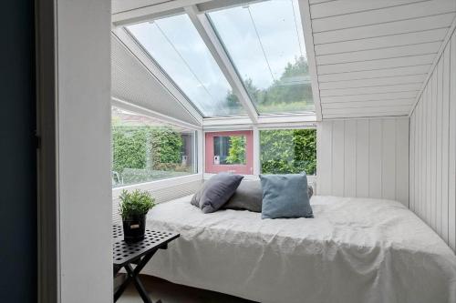 a bedroom with a bed in a room with a window at 40106-Juelsminde-Fasanlunden-34 in Juelsminde