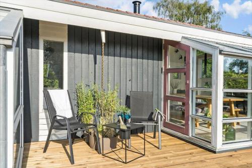 a screened in porch with a table and chairs on a deck at 40106-Juelsminde-Fasanlunden-34 in Juelsminde
